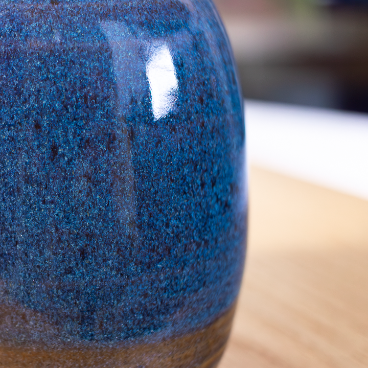 Close-up of a blue ceramic vase on a wooden surface