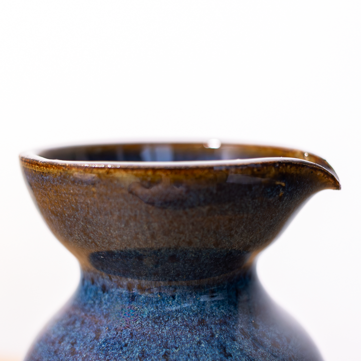 Ceramic pitcher with a brown rim on a white background