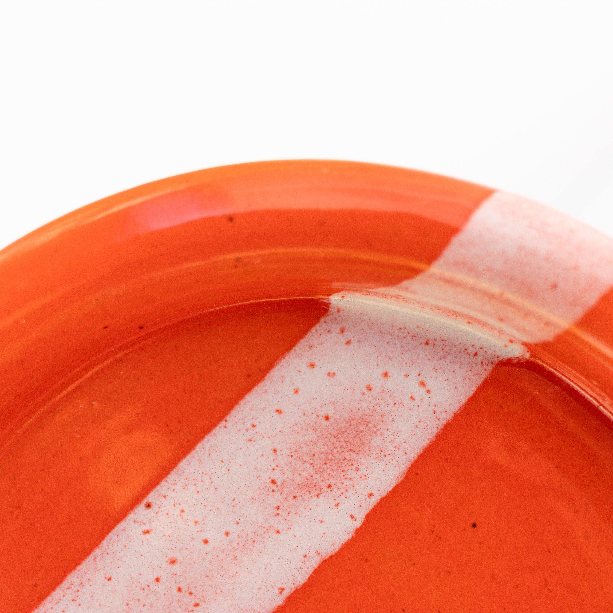 Orange plate with a white stripe on a white background