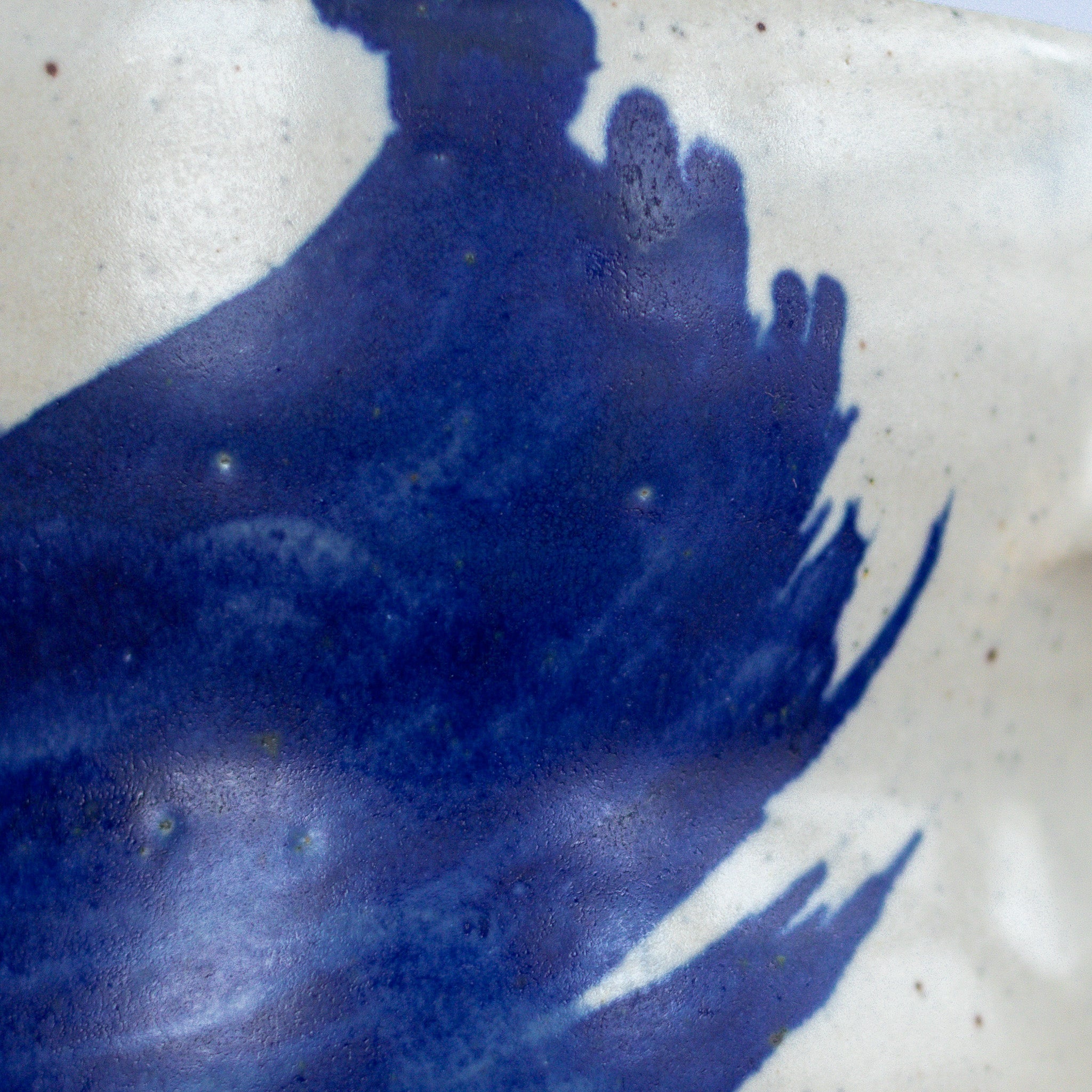 Close-up of a ceramic piece with blue glaze and white base