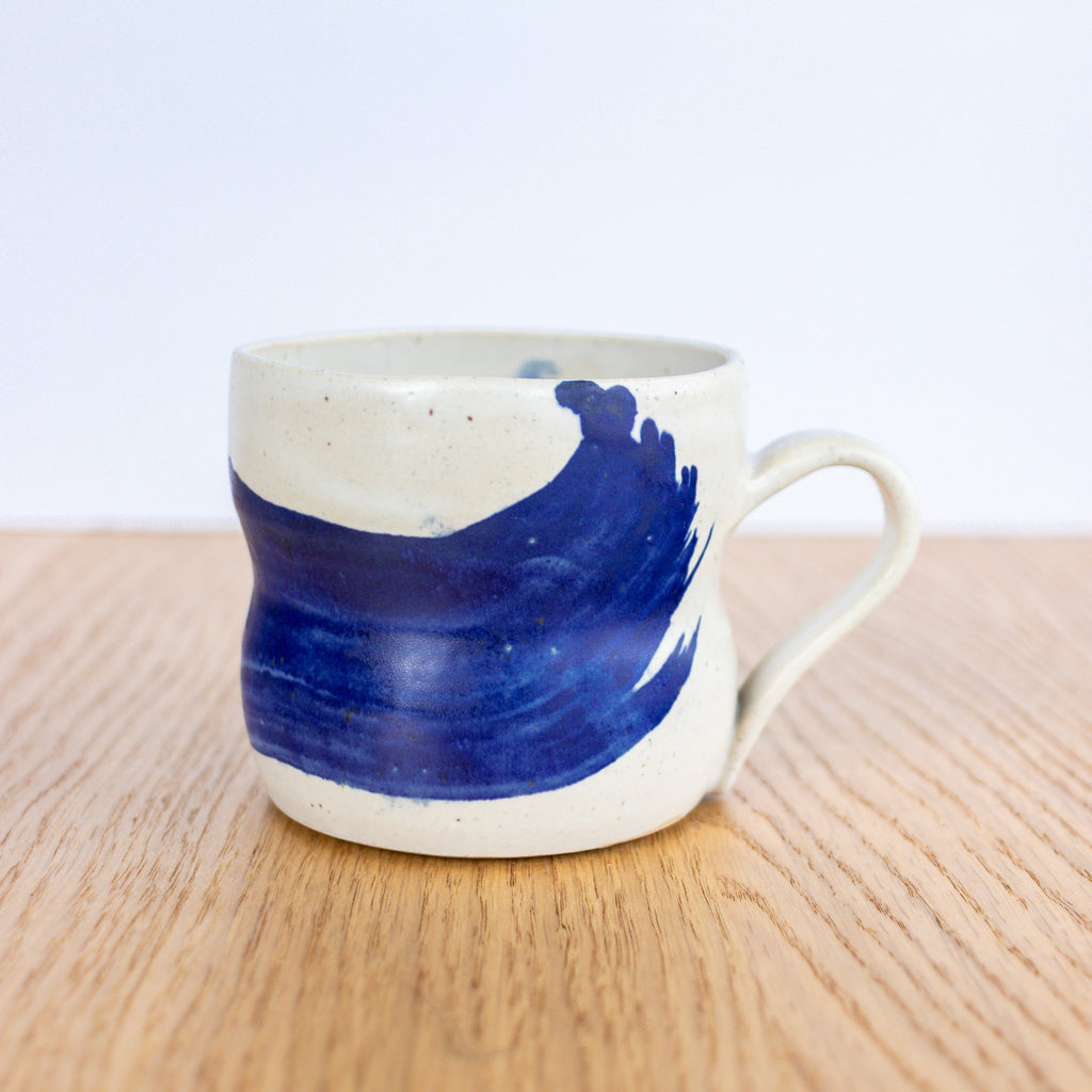 Ceramic mug with blue design on a wooden surface