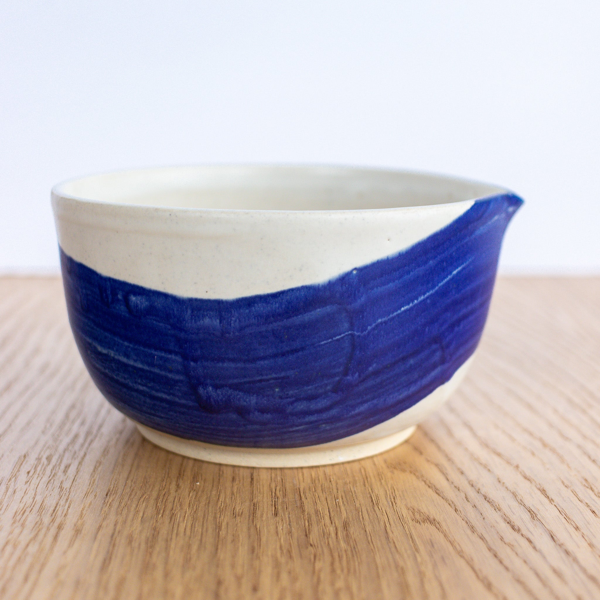 Ceramic bowl with blue accent on a wooden surface